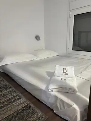 a bed with white sheets and a towel on it at Haraki Beauty in Haraki