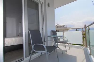 a balcony with two chairs and a table and a bed at Haraki Beauty in Haraki
