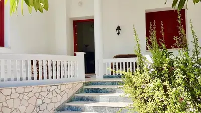 a staircase leading to a house with a red door at The Metropolis Residence Rhodes in Rhodes Town