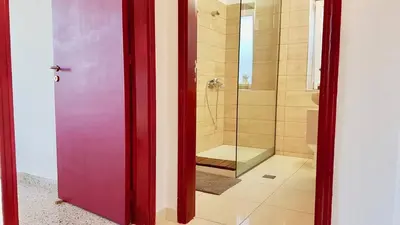 a bathroom with a shower and a purple door at The Metropolis Residence Rhodes in Rhodes Town