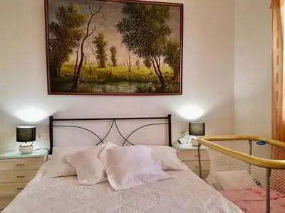 a bedroom with a bed with a painting on the wall at The Metropolis Residence Rhodes in Rhodes Town