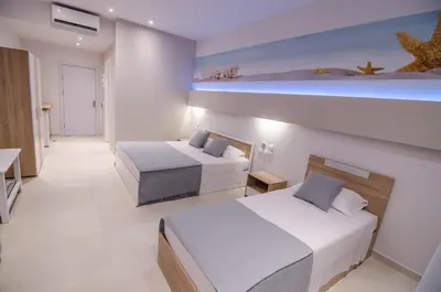 a hotel room with two beds and a room with at Galazio Beach in Faliraki