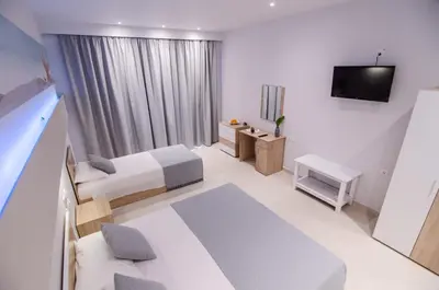 a hotel room with two beds and a television at Galazio Beach in Faliraki