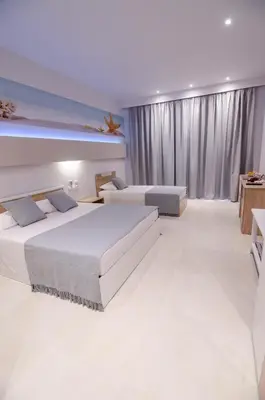 a bedroom with two beds and a large window at Galazio Beach in Faliraki