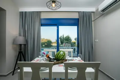 a dining room with a table and a window at RITA MARE seafront villas heated Pools in Gennadi