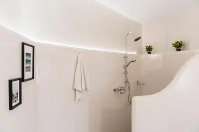 a white bathroom with a shower and a sink at Casa Blue in Gennadi