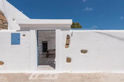 a white building with a blue door on the side at Casa Blue in Gennadi