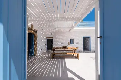 an open door to a patio with a wooden table at Casa Blue in Gennadi