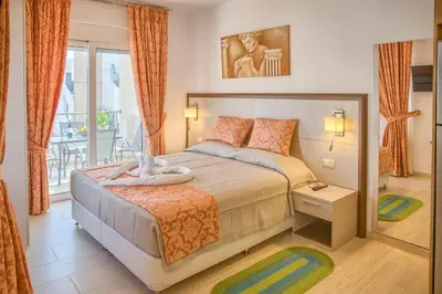 a bedroom with a large bed and a balcony at Haraki Bay Hotel and Luxury Apartments in Haraki