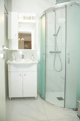 a bathroom with a sink and a glass shower at Haraki Bay Hotel and Luxury Apartments in Haraki