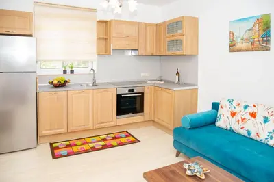 a kitchen with wooden cabinets and a blue couch at Haraki Bay Hotel and Luxury Apartments in Haraki