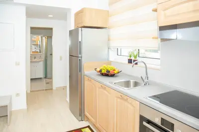 a kitchen with a sink and a stainless steel refrigerator at Haraki Bay Hotel and Luxury Apartments in Haraki