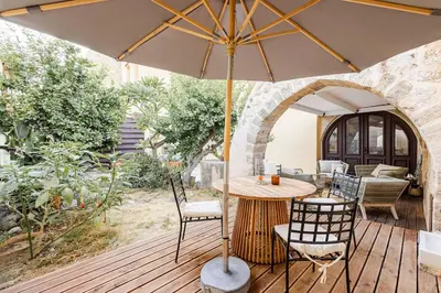 an umbrella on a deck with a table and chairs at Casa de La Flora by Rhodes4vacation in Rhodes Town
