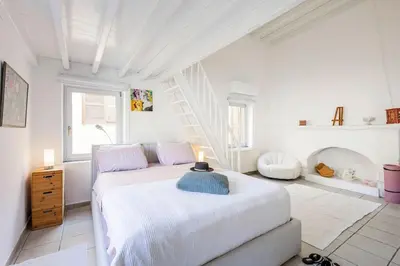 a white bedroom with a bed and a staircase at Casa de La Flora by Rhodes4vacation in Rhodes Town