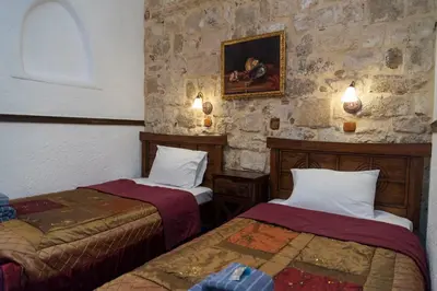 a room with two beds and a stone wall at Spot Hotel in Rhodes Town