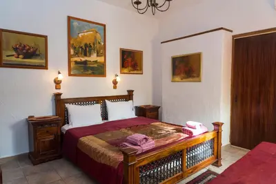 a bedroom with a bed in a room with paintings at Spot Hotel in Rhodes Town