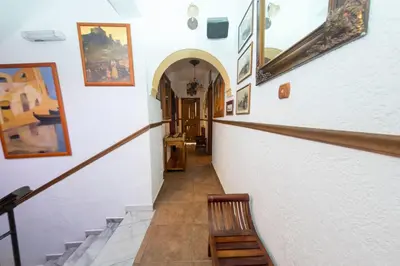 a hallway with a staircase with paintings on the walls at Spot Hotel in Rhodes Town