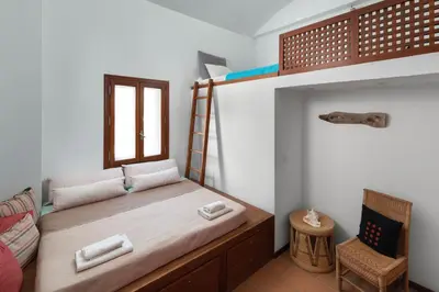 a bedroom with a bunk bed and a chair at lindos kerylos villa in Líndos