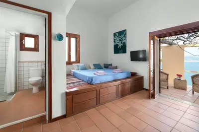 a bedroom with a bed and a bathroom at lindos kerylos villa in Líndos