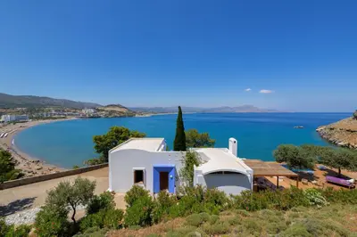 a white house with a view of a beach at lindos kerylos villa in Líndos