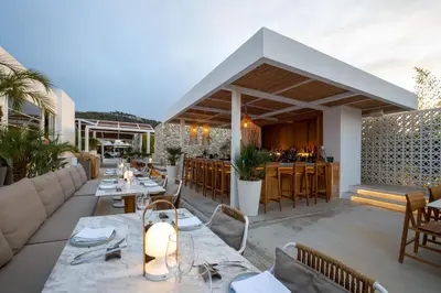 a restaurant with tables and chairs and a bar at Kouros Exclusive Hotel & Suites - Adults Only in Faliraki