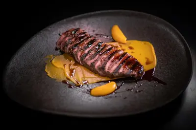 a plate of food with a piece of meat and cheese at Kouros Exclusive Hotel & Suites - Adults Only in Faliraki