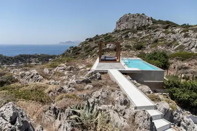 a house on a hill with a swimming pool at Kouros Exclusive Hotel & Suites - Adults Only in Faliraki