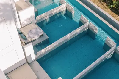 an overhead view of a swimming pool with a chair at Kouros Exclusive Hotel & Suites - Adults Only in Faliraki