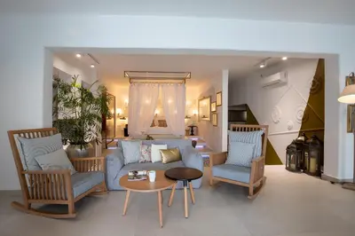 a living room with a couch and two chairs and a table at Kouros Exclusive Hotel & Suites - Adults Only in Faliraki