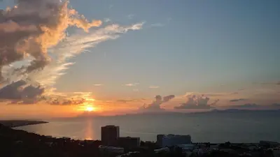 a view of the sun setting over a city at Rhodes SkyLine Suites in Ixia