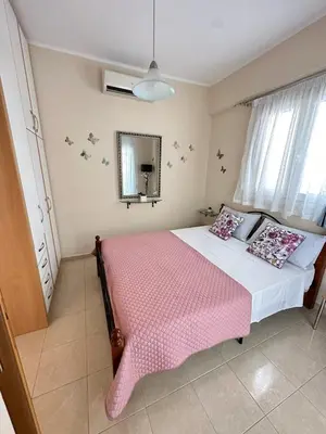a bedroom with a pink bed and a mirror at Orfeas Sea View House in Archangelos