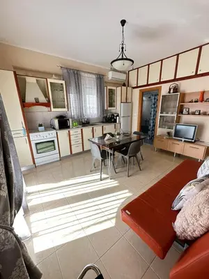 a kitchen and living room with a table and chairs at Orfeas Sea View House in Archangelos