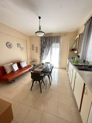 a kitchen and living room with a table and a couch at Orfeas Sea View House in Archangelos