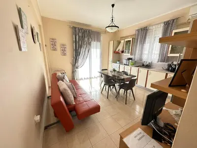 a living room with a red couch and a table at Orfeas Sea View House in Archangelos