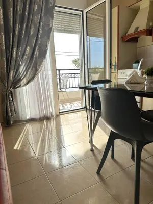 a kitchen with a table and chairs and a balcony at Orfeas Sea View House in Archangelos