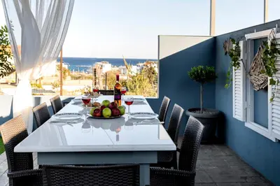 a white table with a bowl of fruit on a patio at Royal Luxury Studios in Archangelos