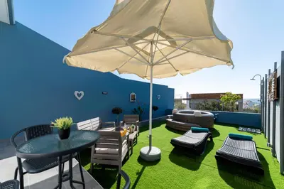 a patio with a table and chairs and an umbrella at Royal Luxury Studios in Archangelos