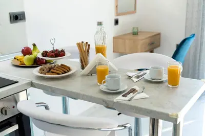 a breakfast table with breakfast foods and orange juice at Royal Luxury Studios in Archangelos