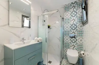 a bathroom with a shower and a sink and a toilet at Royal Luxury Studios in Archangelos