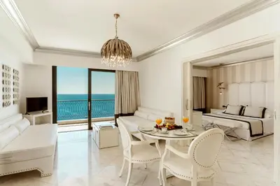 a living room with a bed and a table and chairs at Mitsis Selection Alila in Faliraki