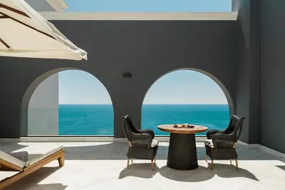 a room with three arched windows and a table and chairs at Mitsis Selection Alila in Faliraki