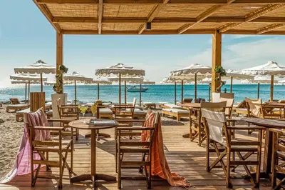 a restaurant on the beach with tables and chairs at Mitsis Selection Alila in Faliraki
