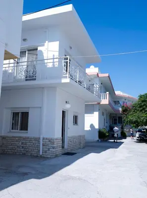 a white building with a balcony on top of it at Haraki Beach Mediterranean Retreat in Haraki