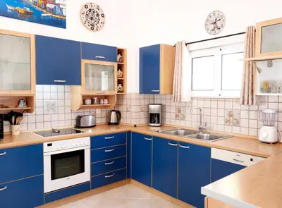 a blue kitchen with wooden counters and cabinets at Haraki Beach Mediterranean Retreat in Haraki