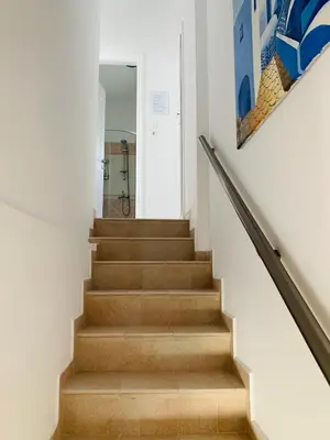 a staircase in a house with a painting on the wall at Haraki Beach Mediterranean Retreat in Haraki