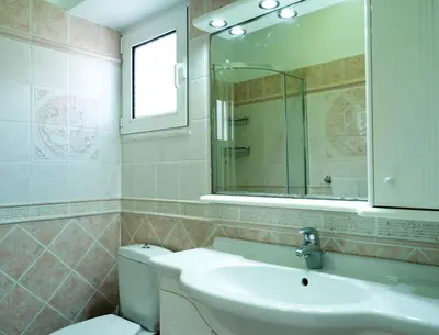 a bathroom with a sink and a toilet and a mirror at Haraki Beach Mediterranean Retreat in Haraki