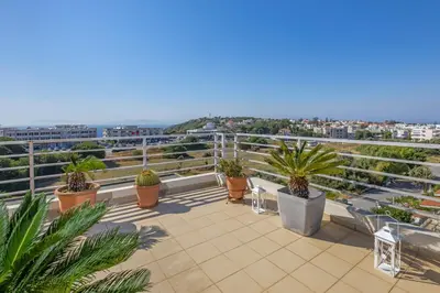 a balcony with potted plants on top of a building at Sunny Penthouse,Modern Amenities+Aegean View in Rhodes Town