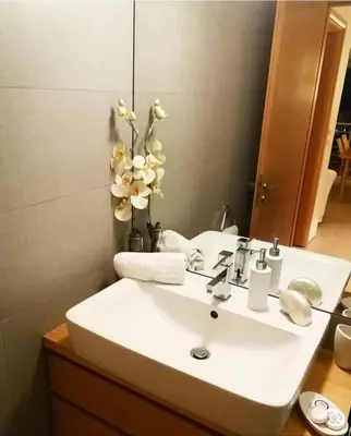 a bathroom with a white sink with a vase of flowers at Sunny Penthouse,Modern Amenities+Aegean View in Rhodes Town