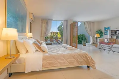 a bedroom with a large bed and a balcony at Couple's Getaway , Modern Amenities & Sophisticated Style in Rhodes Town