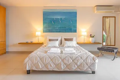 a bedroom with a bed and a painting on the wall at Couple's Getaway , Modern Amenities & Sophisticated Style in Rhodes Town
